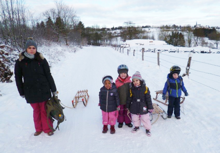 Kinder und Erzieherin im Schnee
